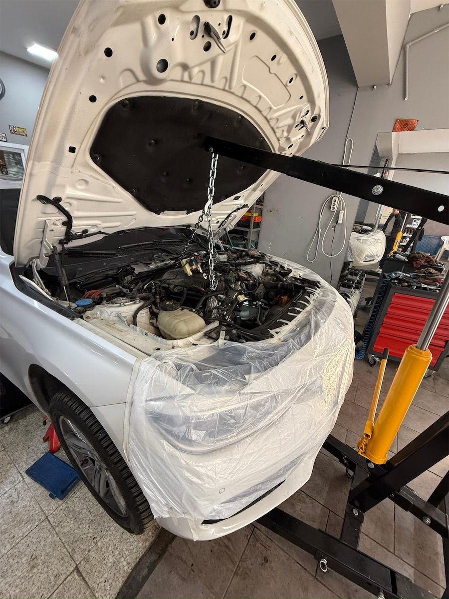 EF Garage Dikmen atölyesinde koruma örtüsüyle kaplanmış araçta motor onarımı